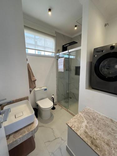 a bathroom with a toilet and a washing machine at Sobrado da Matriz in São Lourenço