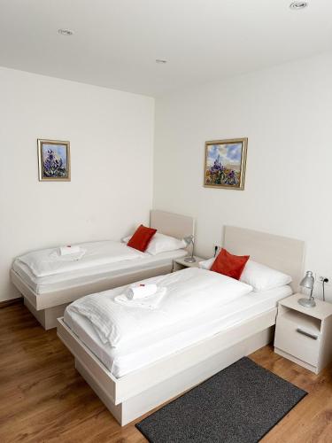 two beds in a room with white walls at Rooms Lidija in Zagreb