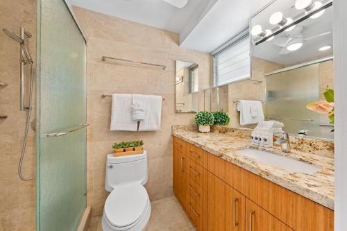 a bathroom with a toilet and a sink and a mirror at Napili Surf 207 · NSF 207 BeachFront Condo Napili Bay in Kahana