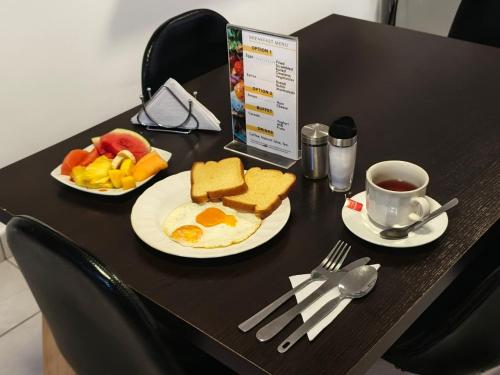 メデジンにあるAir Guest House - con Desayuno & Jacuzzi Socialの2枚の皿に盛られた食べ物とコーヒーカップが置かれたテーブル