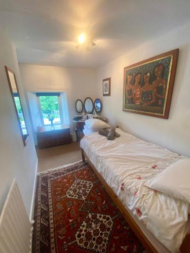 パターデールにあるSchool Houseのベッドと壁に絵が飾られた寝室