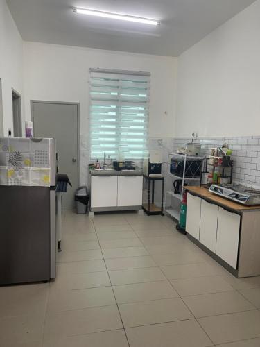 a large kitchen with white tile floors and appliances at Anis Homestay MELAKA in Melaka