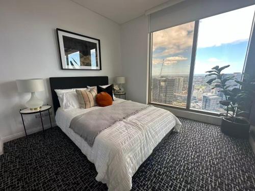 a bedroom with a bed and a large window at Meriton Parramatta in Sydney
