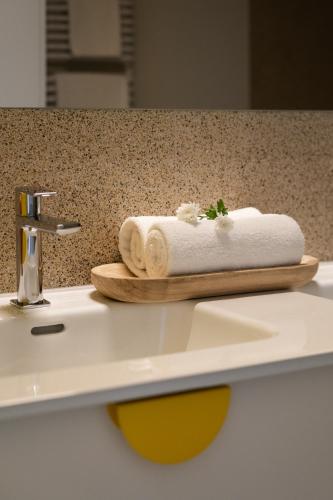 a pile of towels sitting on top of a sink at Trevi Apartments Katowice - City Center - Spodek MCK NOSPR in Katowice