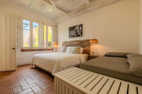 une chambre avec deux lits et une fenêtre dans l'établissement Casa de 5 Hab en la Ciudad Amurallada con Piscina, à Carthagène des Indes