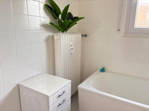 a bathroom with a white tub and a plant at Three room apartment in Bad Oeynhausen Südbahnhof in Bad Oeynhausen