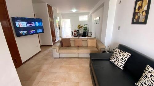 ein Wohnzimmer mit Couch und Flachbildfernseher in der Unterkunft Apartamento con Vista al mar y Terraza, Isla de Margarita in Pampatar