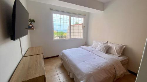 ein Schlafzimmer mit einem Bett und einem Fernseher darin in der Unterkunft Apartamento con Vista al mar y Terraza, Isla de Margarita in Pampatar