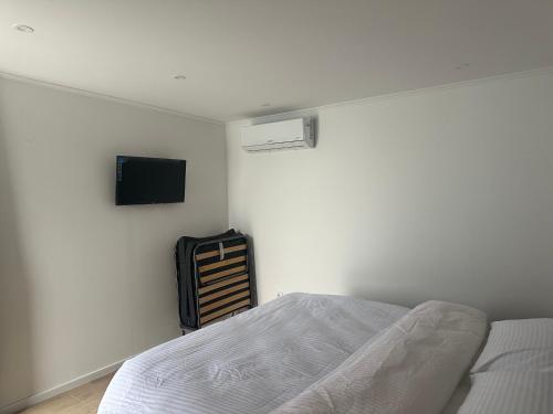 Un dormitorio con una cama y un televisor en la pared. en Daisy3, en Banja Luka