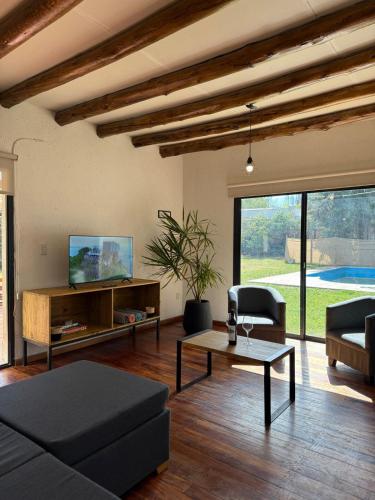a living room with a couch and a tv at Gran Casa con Piscina in Ciudad Lujan de Cuyo