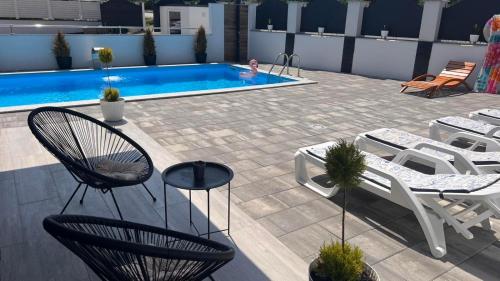 a patio with chairs and a swimming pool at White house Paradise in Bihać