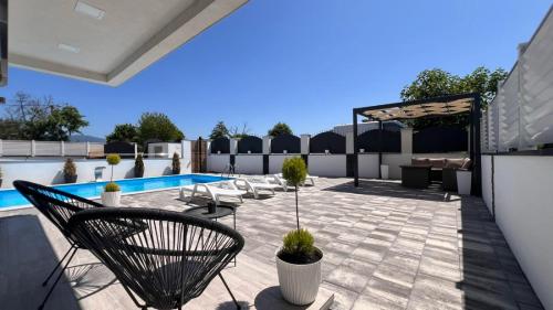 Un patio con sillas y una piscina. en White house Paradise, en Bihać