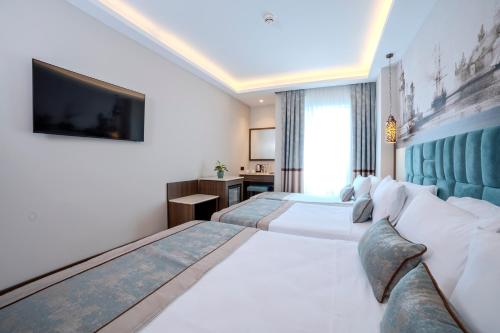 a hotel room with two beds and a flat screen tv at Grand Hilarium Hotel in Istanbul