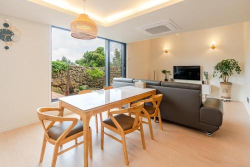 a dining room with a table and chairs and a couch at In Aewol Forest 102 in Haean