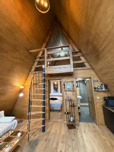 ein Zimmer mit einer Wendeltreppe in einem winzigen Haus in der Unterkunft Wildcabinpanoramic Marisel in Mărişel