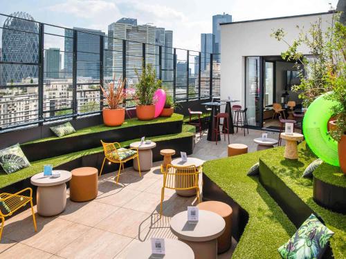 a rooftop patio with tables and chairs on a building at Mercure Paris La Défense in Courbevoie