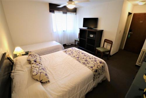 a hotel room with two beds and a television at Hotel Arona in Villa Carlos Paz