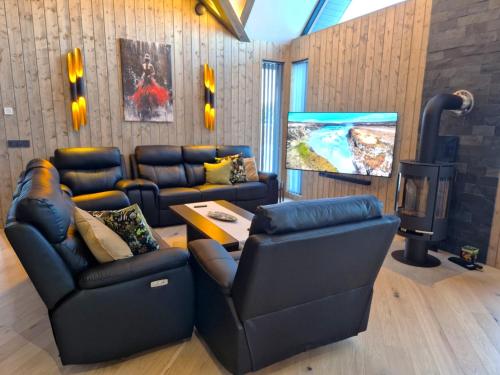een woonkamer met twee banken en een tv bij Garden Villa ' Lava Forest ' in Selfoss