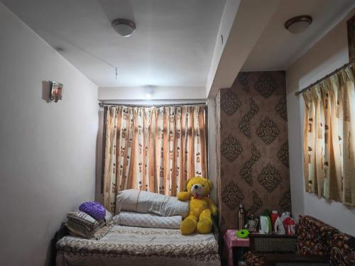 a yellow teddy bear sitting on a bed in a room at 'Timeless Bhaktapur Home' in Bhaktapur