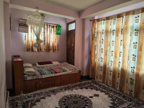 a bedroom with a bed and curtains and a rug at 'Timeless Bhaktapur Home' in Bhaktapur