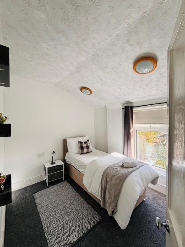 a bedroom with a large bed and a window at Wallasey Nest in Wallasey