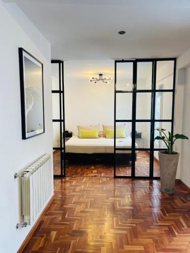 a living room with a bed and a wooden floor at Casa Brown in Neuquén