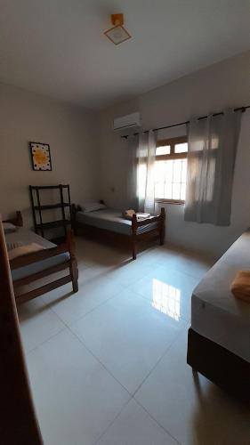 ein großes Zimmer mit zwei Betten und einem Fenster in der Unterkunft Hospedagem, casa Palmas, Conforto e Qualidade in Palmas