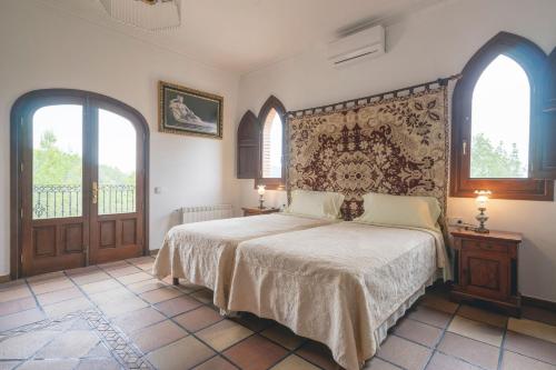 a bedroom with a large bed and two windows at Can Joan Vich ii in Can Furnet