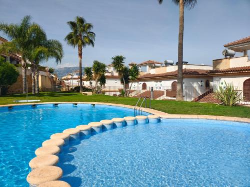 Una gran piscina en un patio con palmeras. en Casa Spa, en Polop