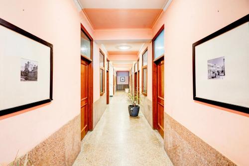 un couloir d'un immeuble de bureaux avec des tableaux aux murs dans l'établissement Hotel O The Swarnim, à Noida