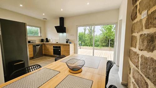 eine Küche und ein Esszimmer mit Tisch und Stühlen in der Unterkunft La maison bleue in Brive-la-Gaillarde