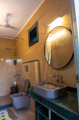 a bathroom with a sink and a toilet and a mirror at Sukoon The घरर in Jodhpur
