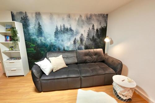 a leather couch in a living room with a painting on the wall at Ferienwohnung Paula in Sankt Georgen im Schwarzwald