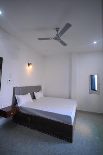 a bedroom with a bed with a ceiling fan at The Light House in Varanasi