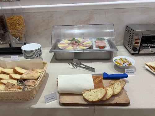 a counter with bread and a plate of food at Mg Palace Hotel Costa del Sole in Vaccarizzo - Delfino