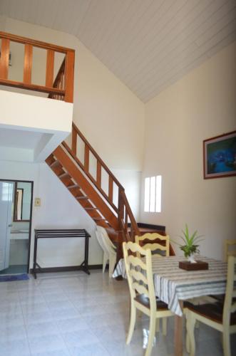 een woonkamer met een trap en een tafel en stoelen bij CleanWave Resort Chumphon คลีนเวฟ รีสอร์ท in Thung Wua Laen Beach