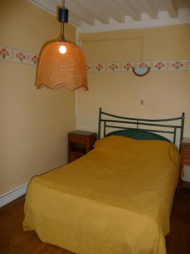 a bedroom with a yellow bed and a lamp at Les Grands-Parents in Corancy