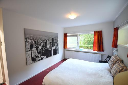 ein Schlafzimmer mit einem weißen Bett und einem Fenster in der Unterkunft Vrijvakantiehuis Rooistrand in Burgh Haamstede