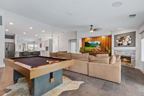 a living room with a pool table and a couch at Navigate Stays Luxe Retreat w Pool Spa & Games in Desert Groves Mobile Home Park