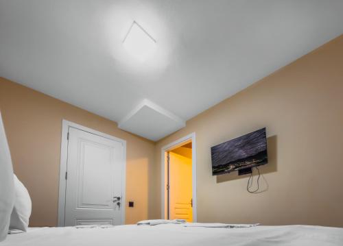 une chambre avec un lit et une télévision au mur dans l'établissement Onze Boutique Hotel Baku, à Baku