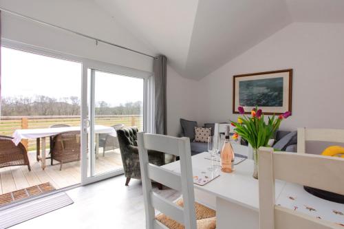 a dining room and living room with a table and chairs at Willow Cottage in Ryde