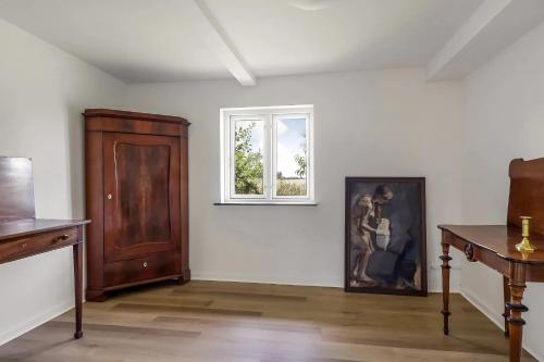 HesselagerDejlig Feriebolig I Hesselager På Charmerende Sydfyn的白色的房间,设有窗户和墙上的绘画