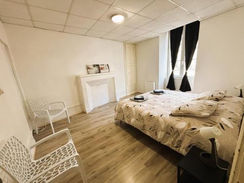 a bedroom with a bed and a table and chairs at Gîte des Débats in Couhé-Verac