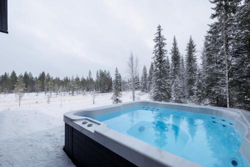 a jacuzzi tub in a snow covered field at Porevillas Iso-Syöte B in Syöte