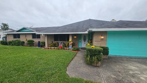 a house with a blue garage and a yard at Jacksonville Waterfront Retreat 3BR 3BA Fishing Dock River Views in Jacksonville