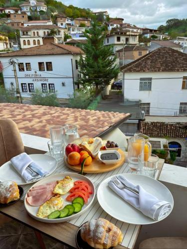 een tafel met borden met ontbijtvoedsel op een balkon bij Villa Mishel in Berat