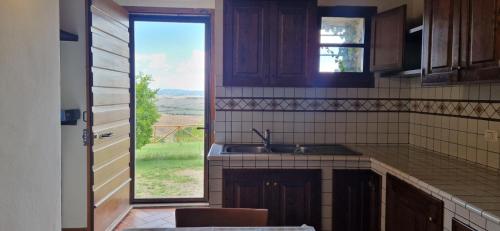 een keuken met een wastafel en een groot raam bij Agriturismo La Rugiada di Pociano in Monteroni dʼArbia