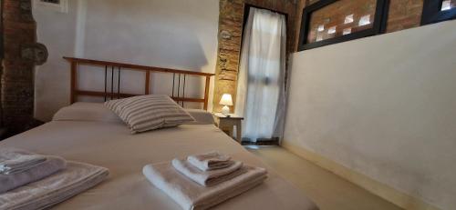 een slaapkamer met twee bedden met handdoeken erop bij Agriturismo La Rugiada di Pociano in Monteroni dʼArbia