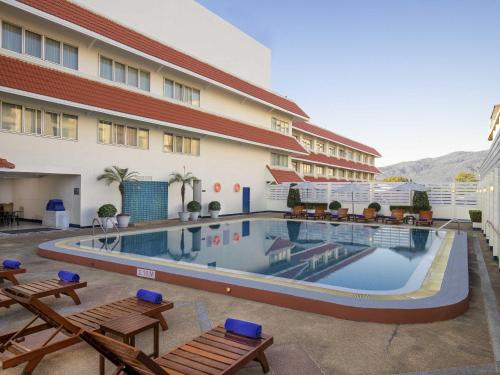 a hotel with a swimming pool in front of a building at Mercure Chiang Mai in Chiang Mai