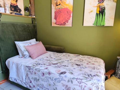 a bedroom with a bed with a pink pillow and pictures at Fynbos Single Stay in Langebaan